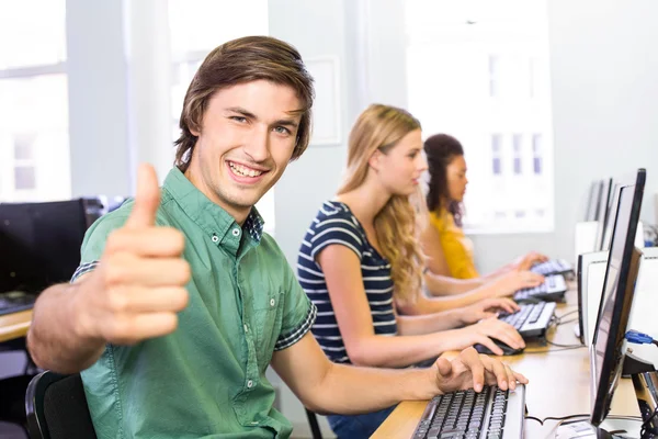 Studente gesticolando pollici in alto nella classe di computer — Foto Stock