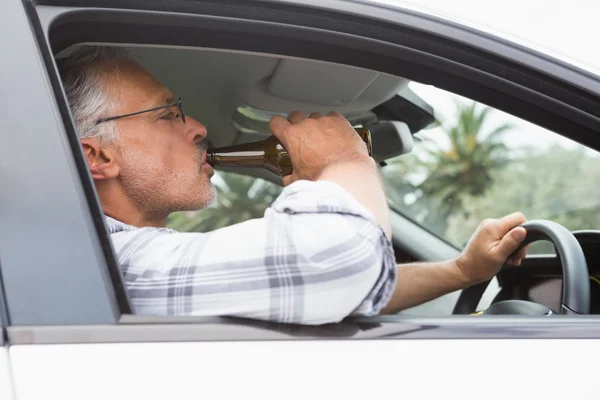 Hombre bebiendo cerveza mientras conduce — Foto de Stock