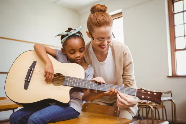 Professor de ensino menina para tocar guitarra em sala de aula — Fotografia de Stock