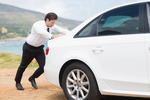 Uomo d'affari spingendo la sua auto — Foto Stock