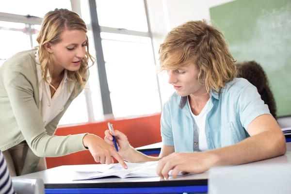 Teacher helping student in class — Stock Photo, Image