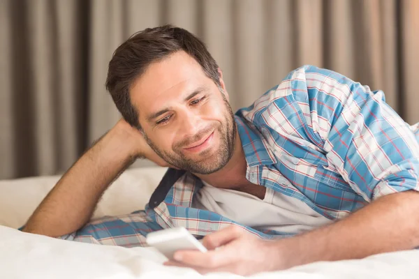 Handsome man relaxing on his bed — Stock Photo, Image