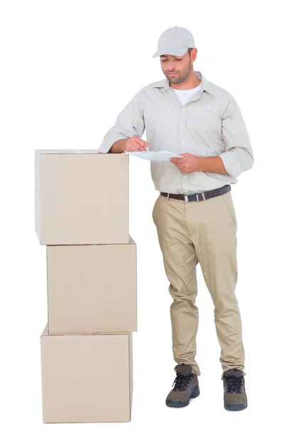 Delivery man writing on clipboard — Stock Photo, Image