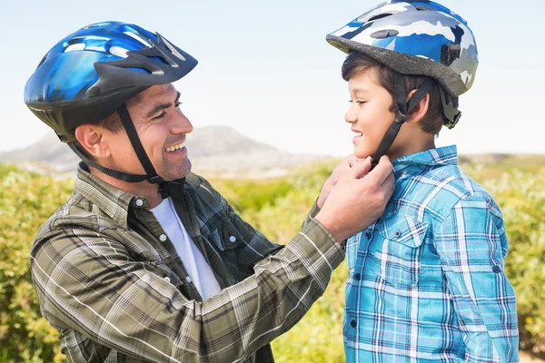 Vader verbonden zijn zoon fietshelm — Stockfoto