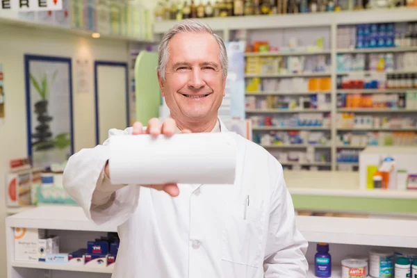 Smiling senior pharmacist showing paper — Stock Photo, Image