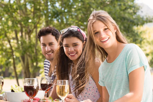 Amigos felices en el parque almorzando — Foto de Stock