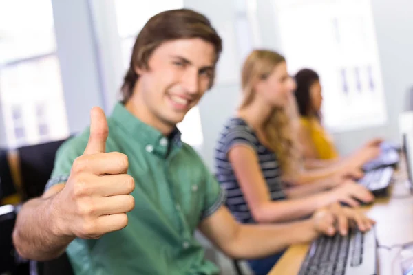 Estudante gesticulando polegares para cima na aula de informática — Fotografia de Stock