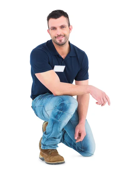 Handyman crouching on white — Stock Photo, Image