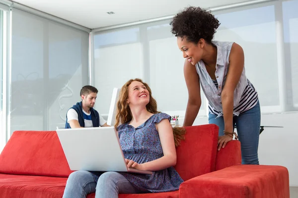 Creative team using laptop on sofa — Stock Photo, Image