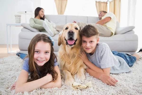 Geschwister liegen mit Hund — Stockfoto