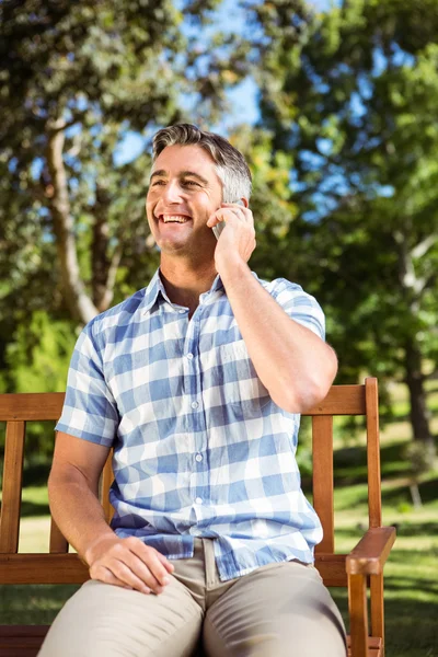 Telefon ile parkta bankta oturan adam — Stok fotoğraf