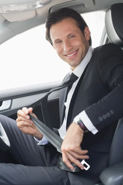 Businessman putting on his seat belt — Stock Photo, Image