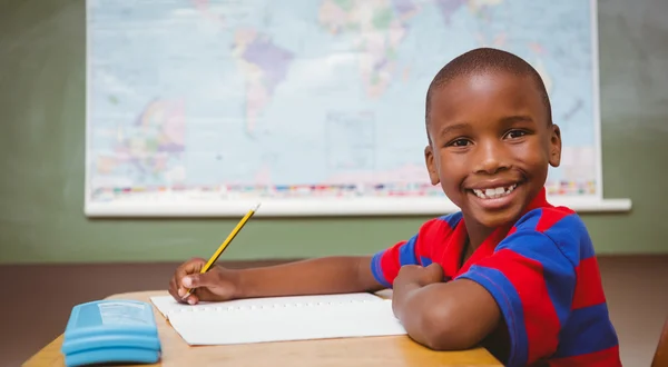 Mignon petit garçon écriture livre dans salle de classe — Photo