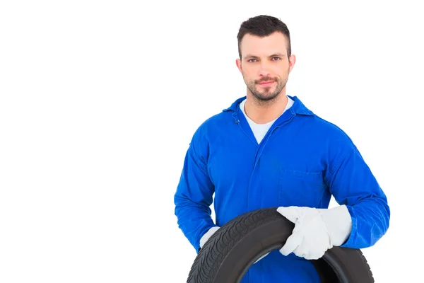 Smiling male mechanic holding tire — Stock Photo, Image