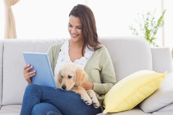 Mooie vrouw met hond met behulp van digitale tablet op Bank — Stockfoto