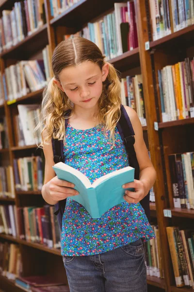 Dívka čtení knihy v knihovně — Stock fotografie
