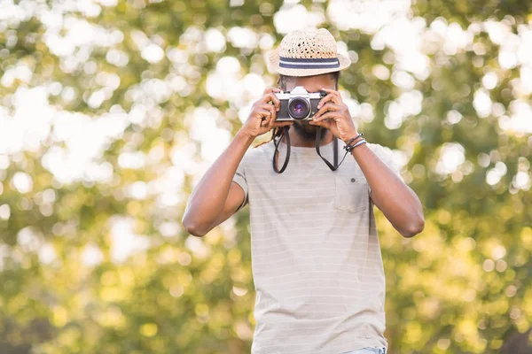 Handsome hipster using vintage camera — Stock Photo, Image