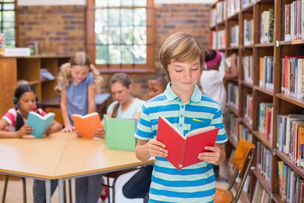 Netter Schüler sucht Bücher in Bibliothek — Stockfoto