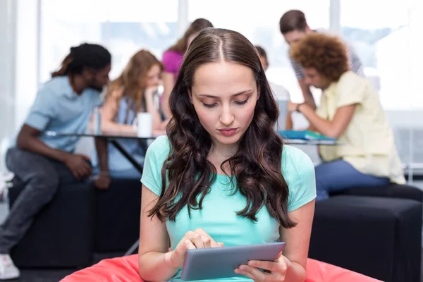 Student pomocí digitálních tabletu s přáteli v pozadí — Stock fotografie