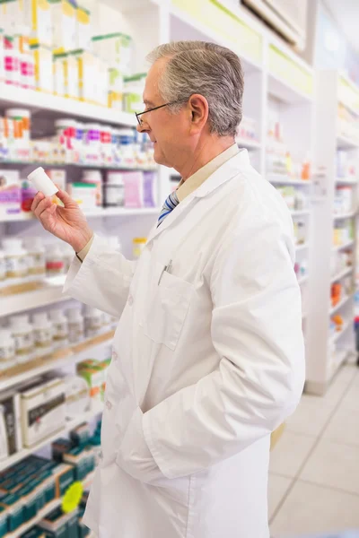 Smiling senior pharmacist holding medication — Stock Photo, Image