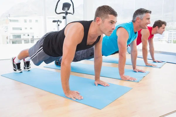 Grupo de homens que trabalham no tapete de exercício — Fotografia de Stock