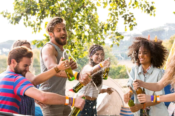 Hipsters spraying beer over each other — Stock Photo, Image