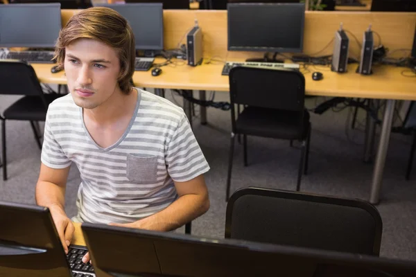 Студент, що працює на комп'ютері в класі — стокове фото