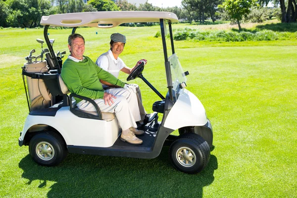 Golfing friends driving in their golf buggy