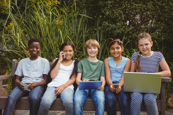 Bambini che usano le tecnologie nel parco — Foto Stock