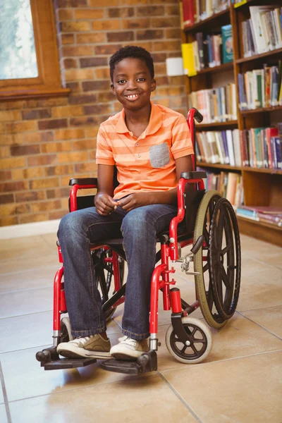 Boy sitting in wheelchair at library — Stock Photo, Image