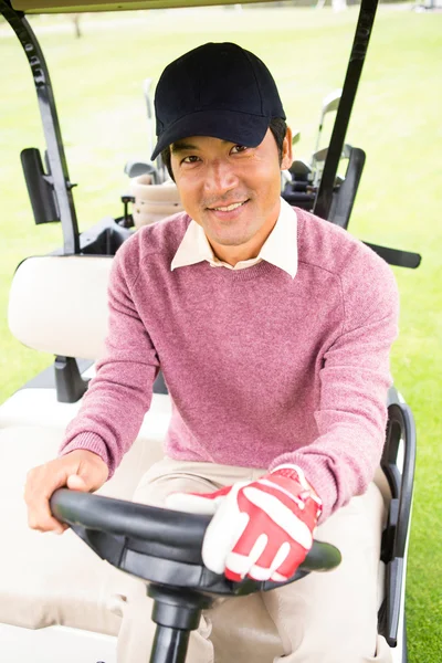 Happy golfer driving his golf buggy — Stock Photo, Image