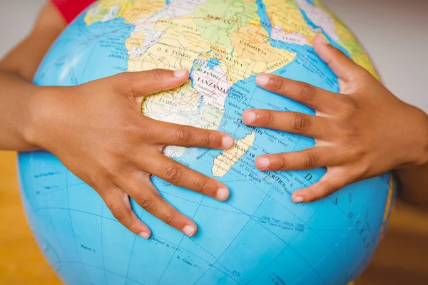 Hands on globe in classroom — Stock Photo, Image