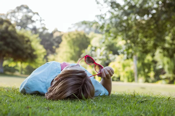 Pretty woman lying down in park — Stock Photo, Image