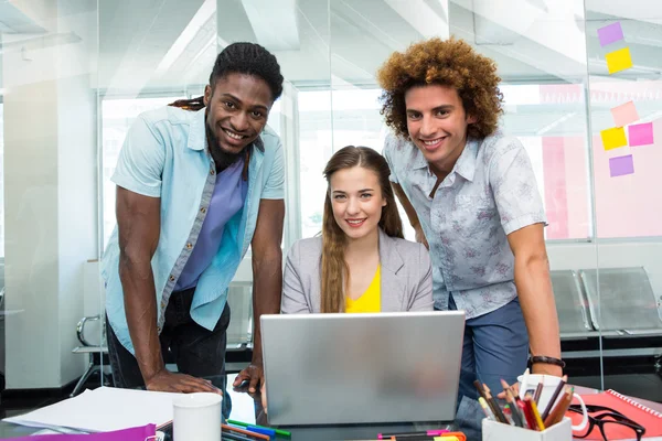 Creative business people using laptop at desk — Stock Photo, Image