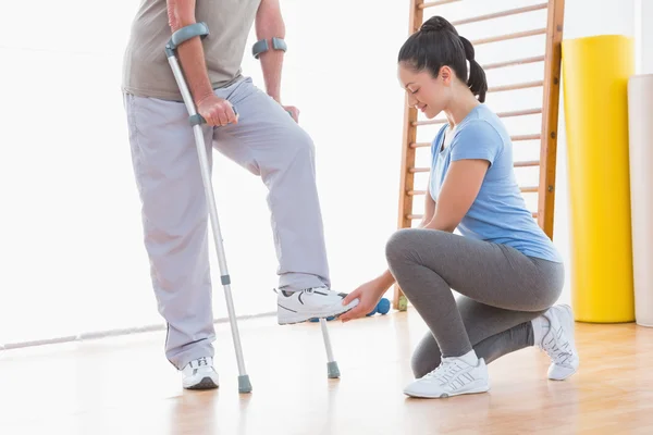 Coach helping senior man to walk — Stock Photo, Image