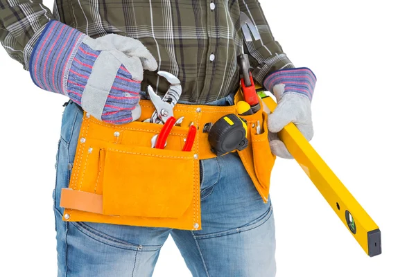 Handyman holding spirit level — Stock Photo, Image