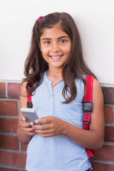 Cute pupil using mobile phone — Stock Photo, Image