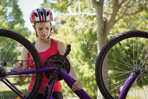 Fit vrouw tot vaststelling van de keten op fiets — Stockfoto