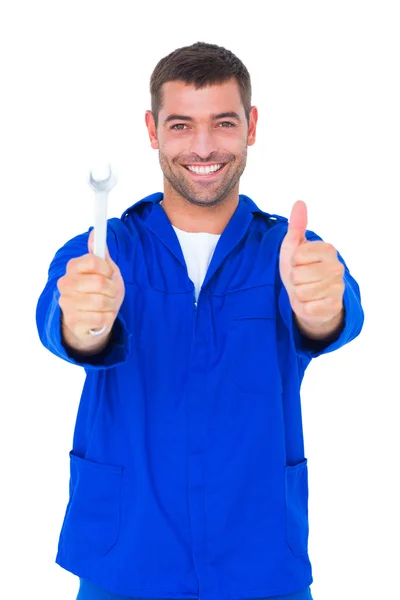 Smiling mechanic holding spanner — Stock Photo, Image