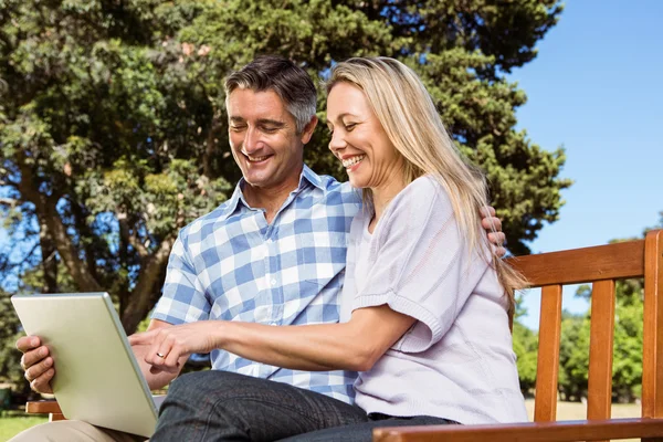 Par avkopplande i parken med laptop — Stockfoto