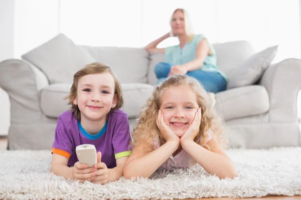 Happy children lying on rug — Stock Photo, Image