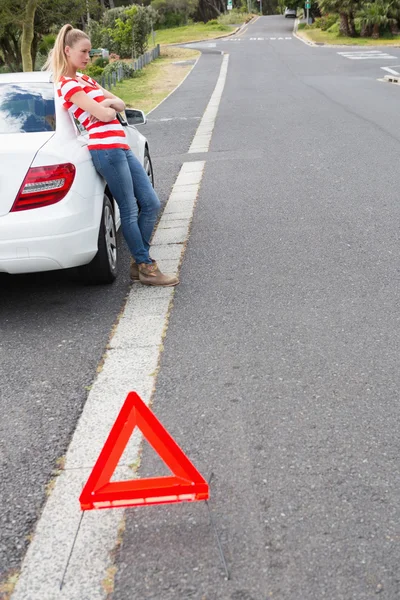 Genervte junge Frau neben ihrem kaputten Auto — Stockfoto