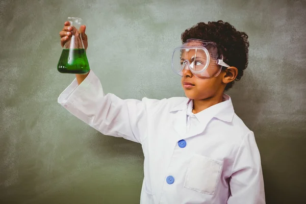 Menino segurando frasco cônico em sala de aula — Fotografia de Stock