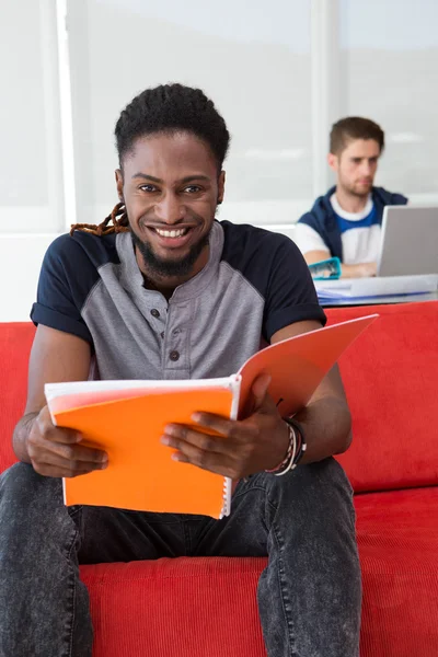 Sonriente joven casual leyendo carpeta —  Fotos de Stock