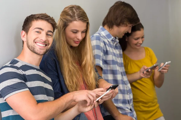 Estudiantes universitarios usando teléfonos celulares —  Fotos de Stock