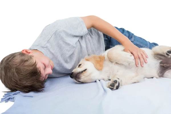 Jongen liggen met puppy op deken — Stockfoto