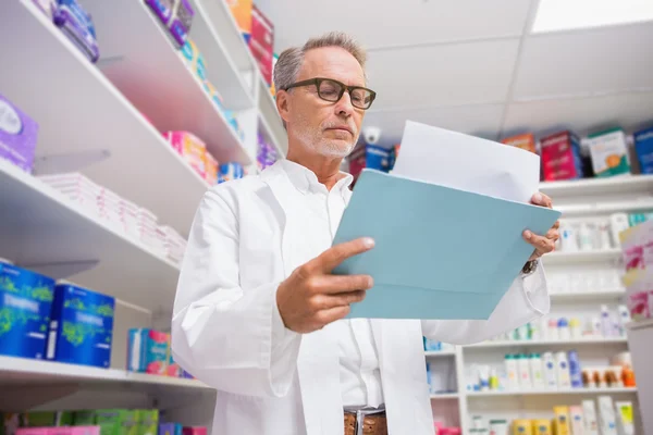 Concentrated pharmacist reading documents — Stock Photo, Image