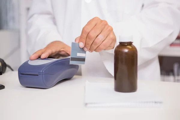Pharmacist using keypad with credit card — Stock Photo, Image