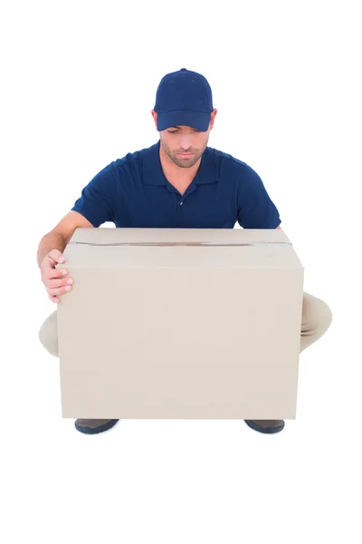 Delivery man picking cardboard box — Stock Photo, Image