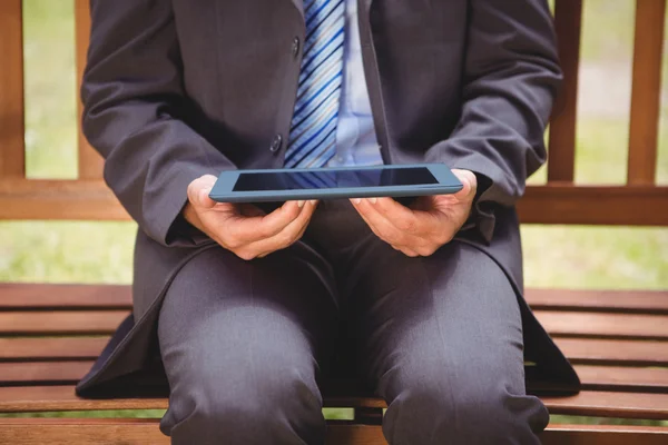 Empresário usando tablet no parque — Fotografia de Stock